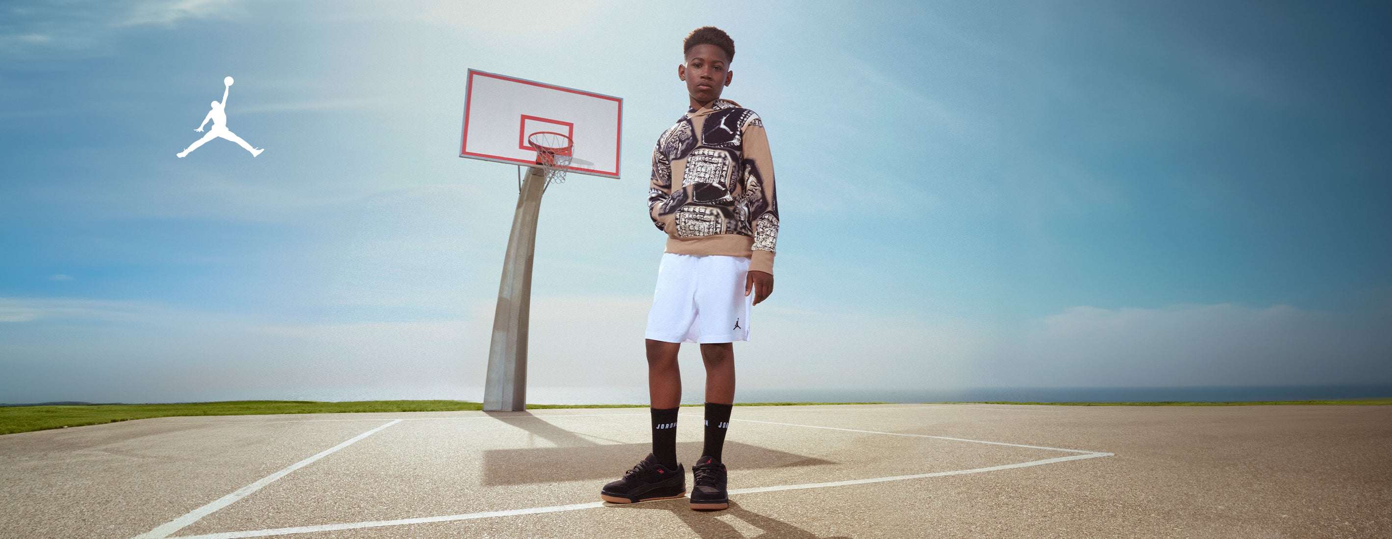 Young boy wearing a Jordan MVP Allover Big Kid Boys Hoodie - Tan and Jordan MJ Essentials Fleece Little Kid Boys Shorts				