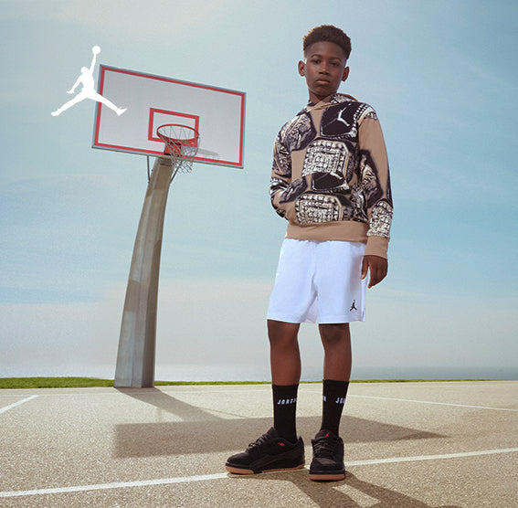 Young boy wearing a Jordan MVP Allover Big Kid Boys Hoodie - Tan and Jordan MJ Essentials Fleece Little Kid Boys Shorts				